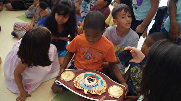 courtesy photo/boys & girls club redlands Children at the Boys & Girls Club in Redlands check out undefeated super lightweight boxer Miguel Angel “Mikey” Garcia’s belt. Garcia spoke to children about never giving up and staying in school.   