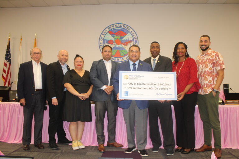 City leaders presenting check for homeless project.