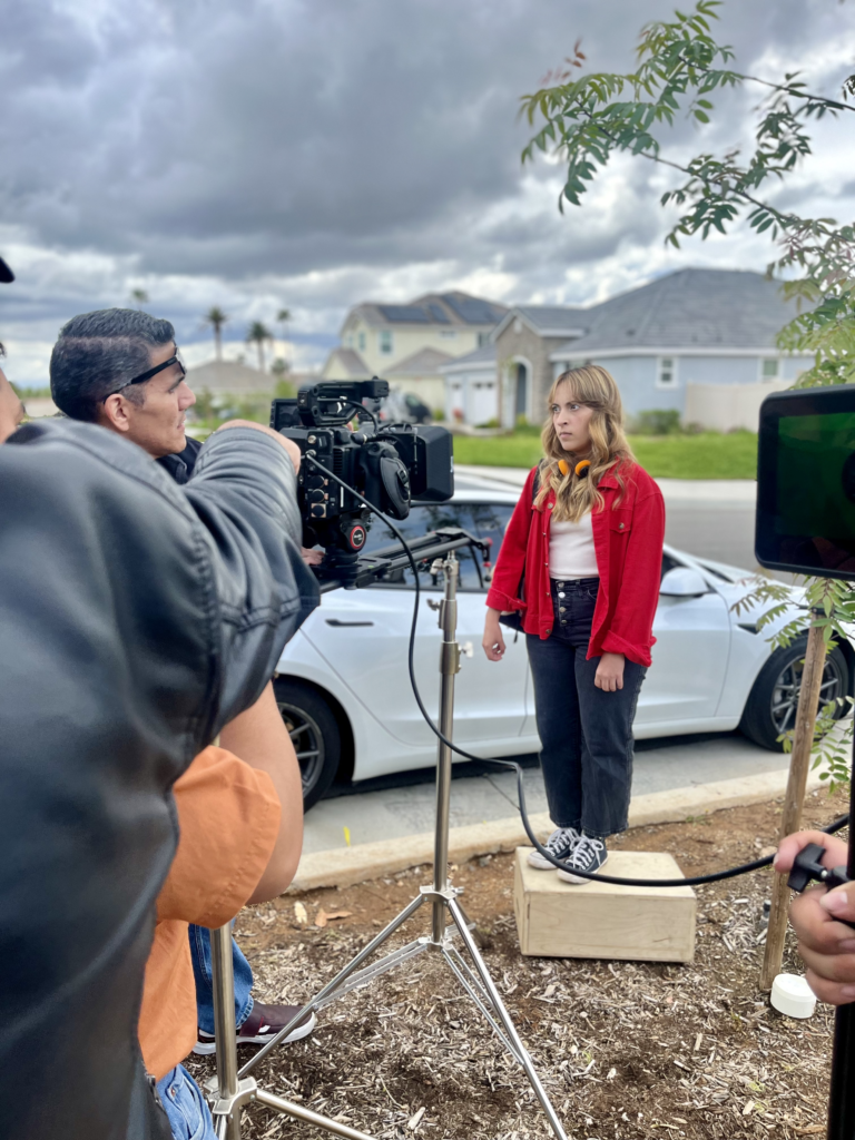 The set of a film where camera men are blocking the actress for a scene.